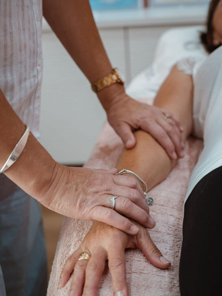 Les mains de Virginie Chaumet posées avec douceur sur le bras d’une consultante
